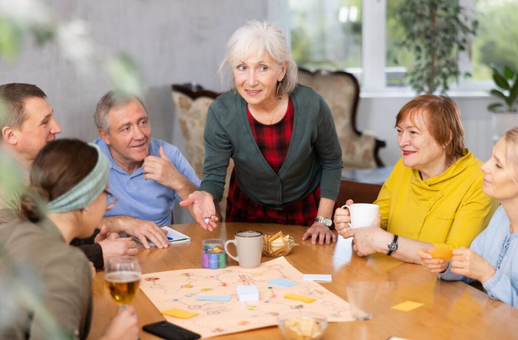 A group of seniors fully emersed in a board game hosted by their assisted living home as part of community building