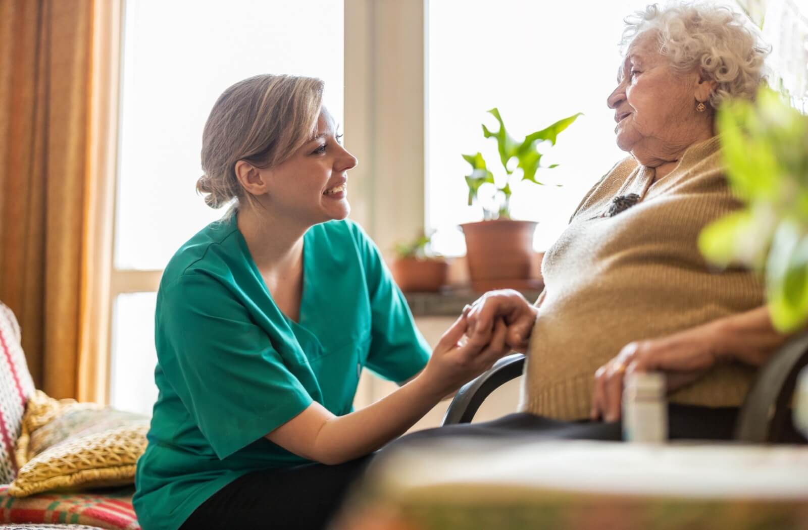 A caring nurse looks up at a senior with dementia to see if they need any assistance on an early morning in memory care