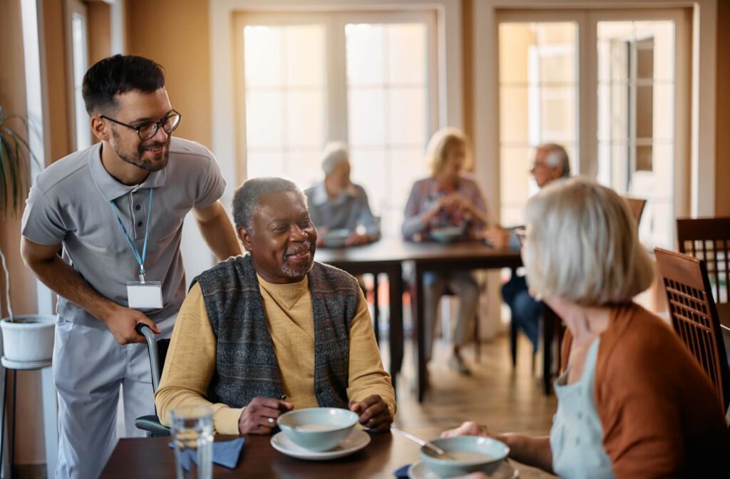 Caregiver checking in seniors while they are enjoying their meal in senior living